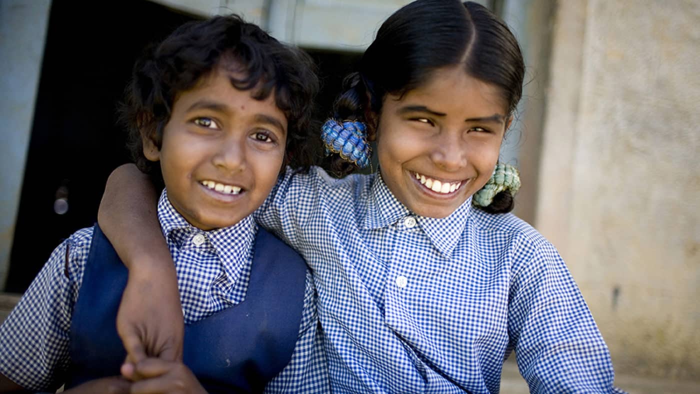 Two children smile at the camera.