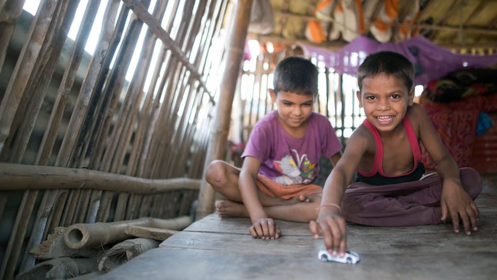 Two children play with toy cars.