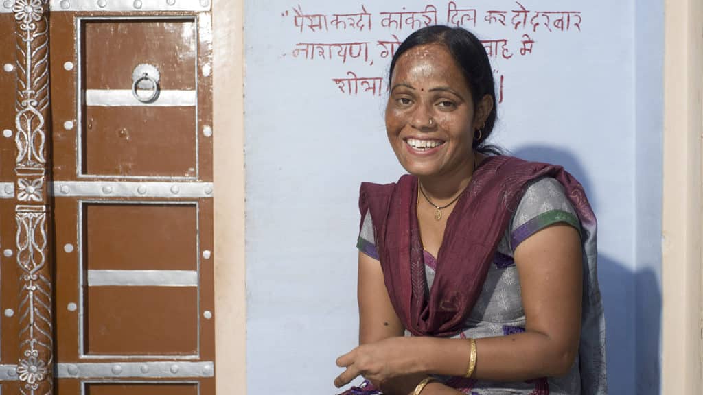 A women sat down smiling.