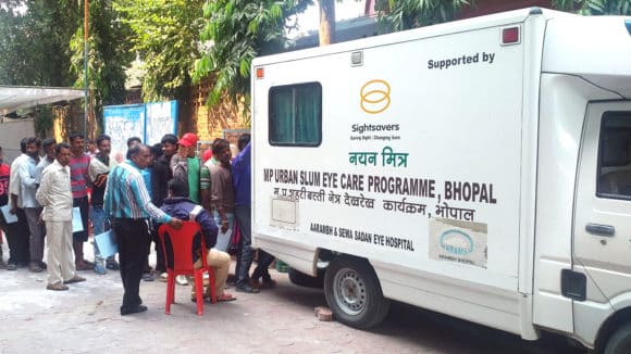 A van which is a mobile vision centre, with the Sightsavers logo on the side.