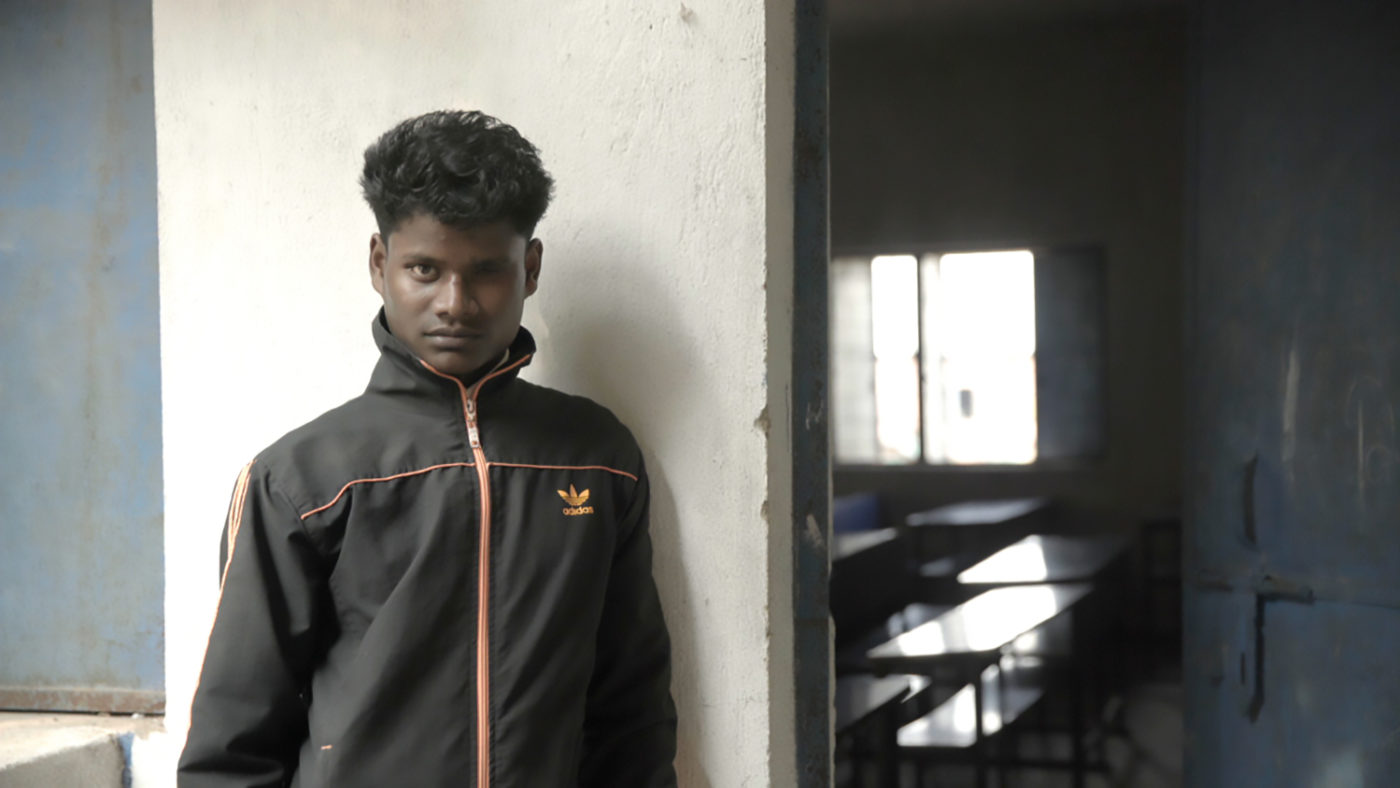 A boy outside a classroom.