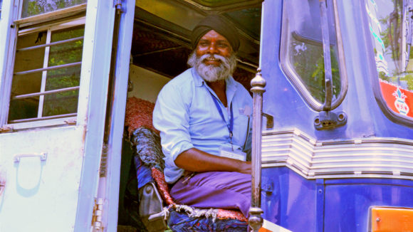 A man sits smiling in a truck.